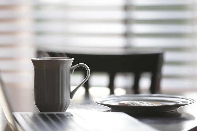 Detail hrnku s kávou, stojící na stole